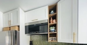 white, green and gold kitchen with added storage shelves and baskets