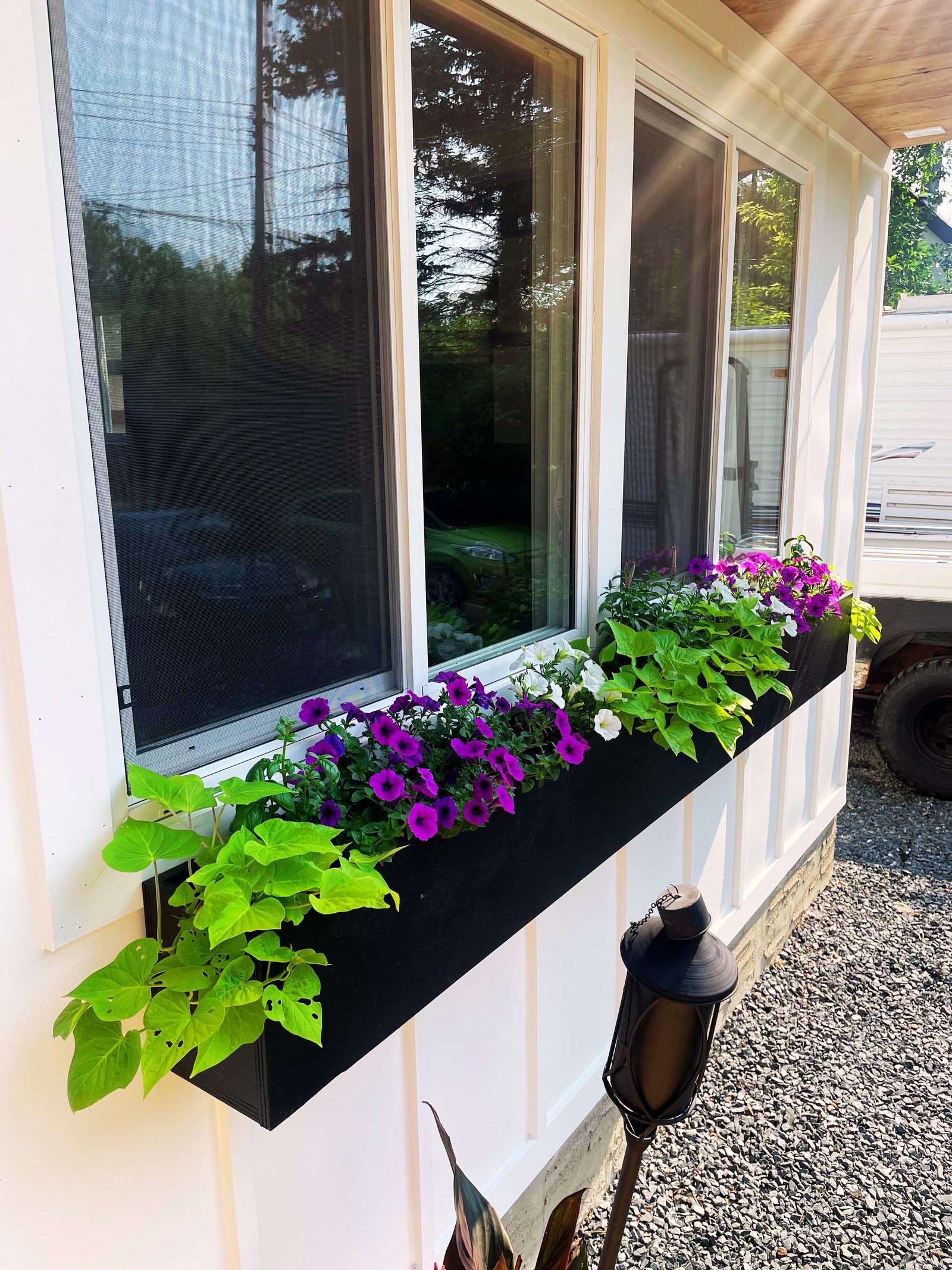 modern DIY rectangluar black window box with purple and white flowers and green vines