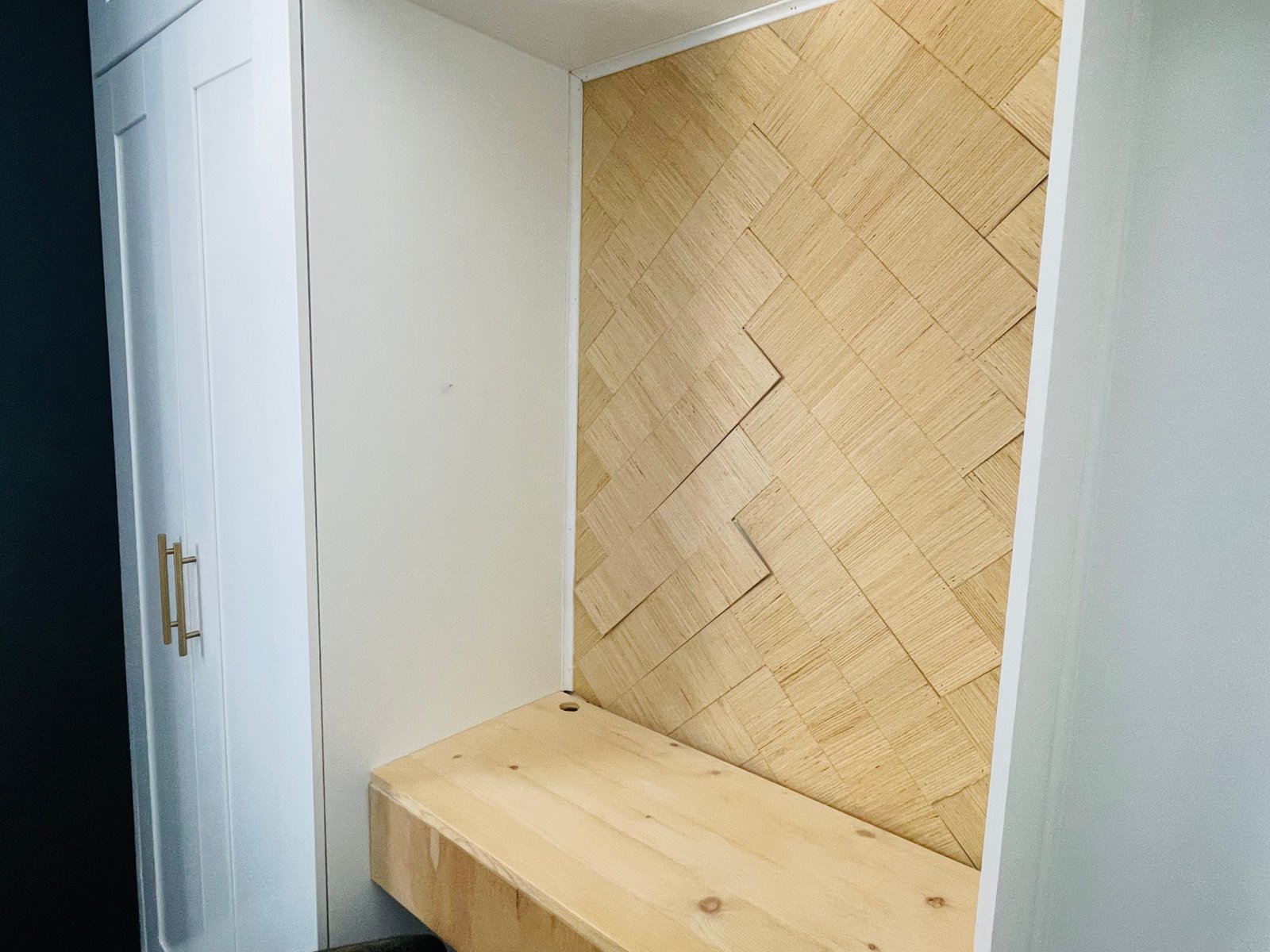 built-in-wardrobe wall with small built in desk and herringbone wood feature